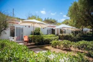 una casa con dos sillas y una sombrilla en Villaggio Vacanza Baia Falcone, en Vieste