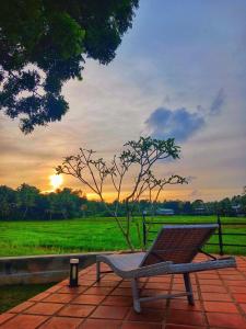 a bench sitting on a brick patio with a tree at Lindy Stays Talpe in Pitiduwa