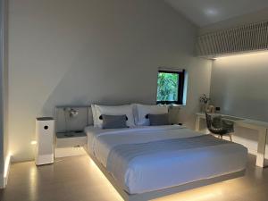 um quarto com uma cama grande e uma janela em Tree Villa Bangkok em Banguecoque