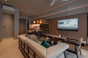 een woonkamer met een bank en een tv aan de muur bij New This is in Genting Highland hill -12mins walk 4pax in Genting Highlands