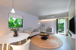 uma sala de estar com uma mesa branca e um sofá branco em Tree Villa Bangkok em Banguecoque