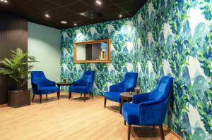 a waiting room with blue chairs and a wall mural at Thon Hotel Verdal in Verdal