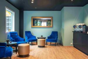 a waiting room with blue chairs and a mirror at Thon Hotel Verdal in Verdal