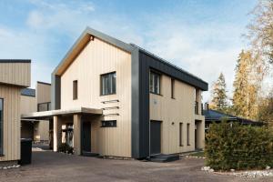 a house with a black roof at Brand new house with four bedrooms, parking, sauna, patio in Vantaa