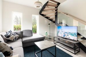 a living room with a couch and a tv at Brand new house with four bedrooms, parking, sauna, patio in Vantaa