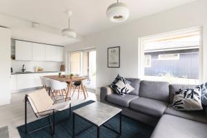 a living room with a couch and a table at Brand new house with four bedrooms, parking, sauna, patio in Vantaa