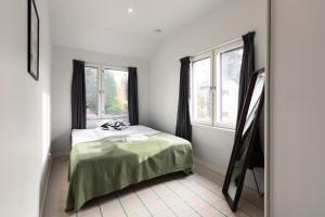 a bedroom with a bed and two windows at Brand new house with four bedrooms, parking, sauna, patio in Vantaa