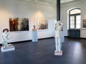 a room with two mannequins and paintings on display at Bungalow THEA in Langhagen