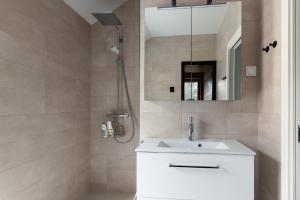 a bathroom with a white sink and a mirror at Brand new house with four bedrooms, parking, sauna, patio in Vantaa +23 photos