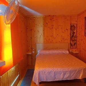 a bedroom with a bed in a room with wooden walls at Nido Playa in Punta Umbría
