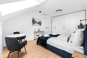 a bedroom with a bed and a desk and a chair at Jack Apartments- Kamień Śląski in Kamień Śląski