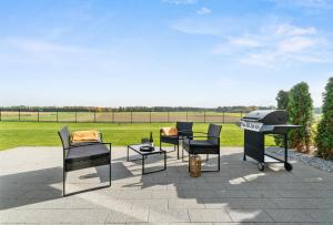 a patio with chairs and a grill and a table at Jack Apartments- Kamień Śląski in Kamień Śląski