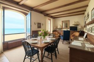 a dining room with a table and chairs with a view of the ocean at La Villa ker Alexis by Cocoonr - Villa Balnéaire dans Saint-Malo in Saint Malo