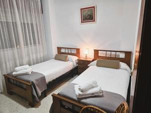 two beds in a room with towels on them at Casa de Pueblo con Encanto in Valderrubio