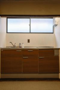 une cuisine avec un évier et deux fenêtres dans l'établissement 東京下町生活, à Tokyo 23 autres photos