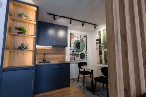 Una cocina con gabinetes azules y una mesa y sillas. en Vidikovac-Berane, en Berane 46 fotos más