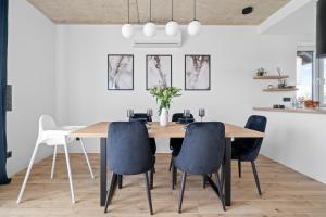 a dining room with a wooden table and chairs at Jack Apartments- Kamień Śląski in Kamień Śląski