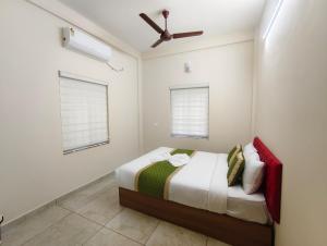 a bedroom with a bed and a ceiling fan at 88 GREEN FORT EDAPALLy in Ernakulam