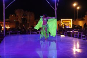 a woman is dancing on a stage at night at Desert Safari Dubai Over Night Stay in Hunaywah