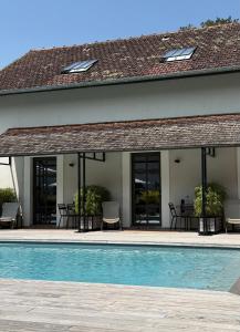 a villa with a swimming pool and a house at Chateau De La Resle - Design Hotels in Montigny-la-Resle