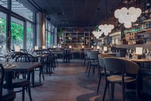 a restaurant with tables and chairs and windows at Quality Hotel Luleå in Luleå