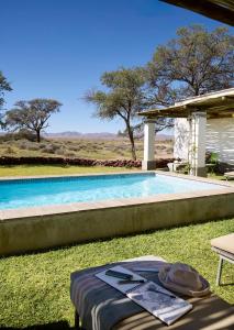 ein Swimmingpool im Gras mit einem Tisch daneben in der Unterkunft Noois’hof Sinclair Nature Reserve in Helmeringhausen + 33 Fotos