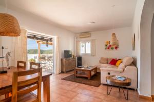ein Wohnzimmer mit Sofa und Tisch in der Unterkunft Villa Torre Xanchu in San Jose de sa Talaia + 14 Fotos