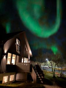 a cabin with the aurora in the sky at Nyoppusset sokkelleilighet med bra bussforbindelser in Kvaloysletta