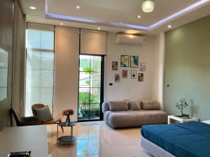 Ban RangengにあるEllie House Phuket Old Townのベッドとソファのあるリビングルーム