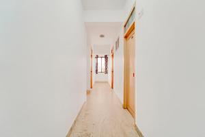 an empty hallway with white walls and wooden floors at Super Collection O Chalai Bazaar Near Railway Station Formerly Galaxy Inn in Trivandrum