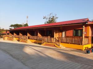 un bâtiment jaune avec un toit rouge et une rue dans l'établissement Baan Berm Family Inn, 