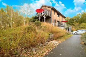 a building with a red umbrella on the side of it at Loft Ôrizon - Domaine De L'ô in Bellacaud