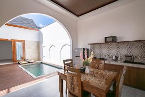 une salle à manger avec une table et une piscine dans l'établissement Il Petrucino Villa, à Nusa Dua