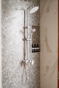 La salle de bains est pourvue d'une douche et d'un mur en pierre. dans l'établissement Il Petrucino Villa, à Nusa Dua