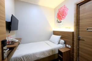 um quarto de hotel com uma cama e uma televisão em Front One Cabin Malioboro Jogja em Yogyakarta