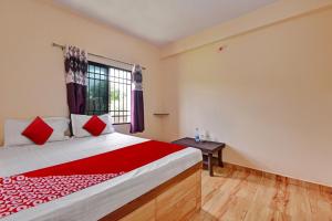 a bedroom with a large bed and a window at Hotel O The Harsa Inn in Sānkchi