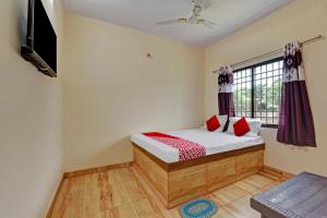 a bedroom with a bed and a window at Hotel O The Harsa Inn in Sānkchi