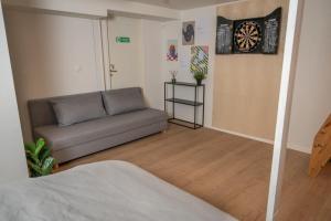 a living room with a couch and a dartboard on the wall at Stvg centre, Heart of the city, 3 Bedroom in Stavanger