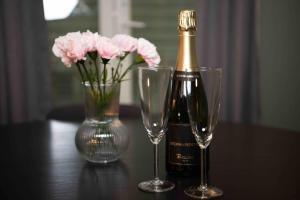 a bottle of champagne and two glasses on a table at Stvg centre, Heart of the city, 3 Bedroom in Stavanger
