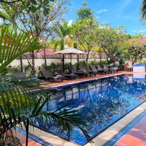 a pool at a resort with chairs and trees at Harmony Indochine d'Angkor in Siem Reap +54 photos