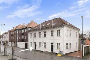 a white building with a white arrow on a street at Stvg centre, Heart of the city, 3 Bedroom in Stavanger