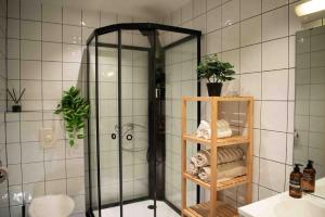 a bathroom with a shower and a shelf with towels at Stvg centre, Heart of the city, 3 Bedroom in Stavanger +25 photos