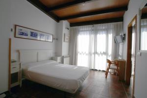 アビラにあるHotel Las Murallasの白いベッドと窓のある寝室