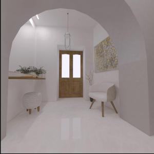 Habitación blanca con puerta de madera y silla en The Wine Suites, en Rodas