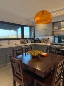a kitchen with a wooden table with a bowl of fruit on it at Villa Odymar Ammouliani in Ammouliani