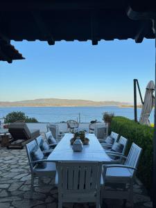 a white table and chairs with a view of the water at Villa Odymar Ammouliani in Ammouliani +19 photos