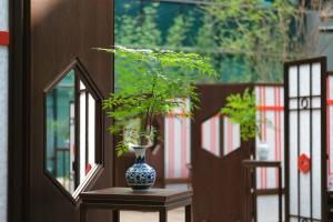 a vase sitting on a table with a plant in it at Hyatt Regency Shanghai Wujiaochang in Shanghai