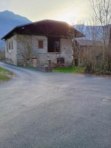 an old stone building with a roof on a road at Maison de Village au pied des montagnes in Randens
