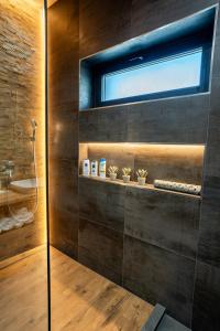 a bathroom with a shower and a window at Zsizell Lux Apartman in Kanjiža