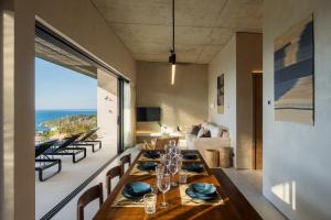 Un comedor con una mesa y sillas y un sofá. en RAKSA Villas, en Ban Madua Wan